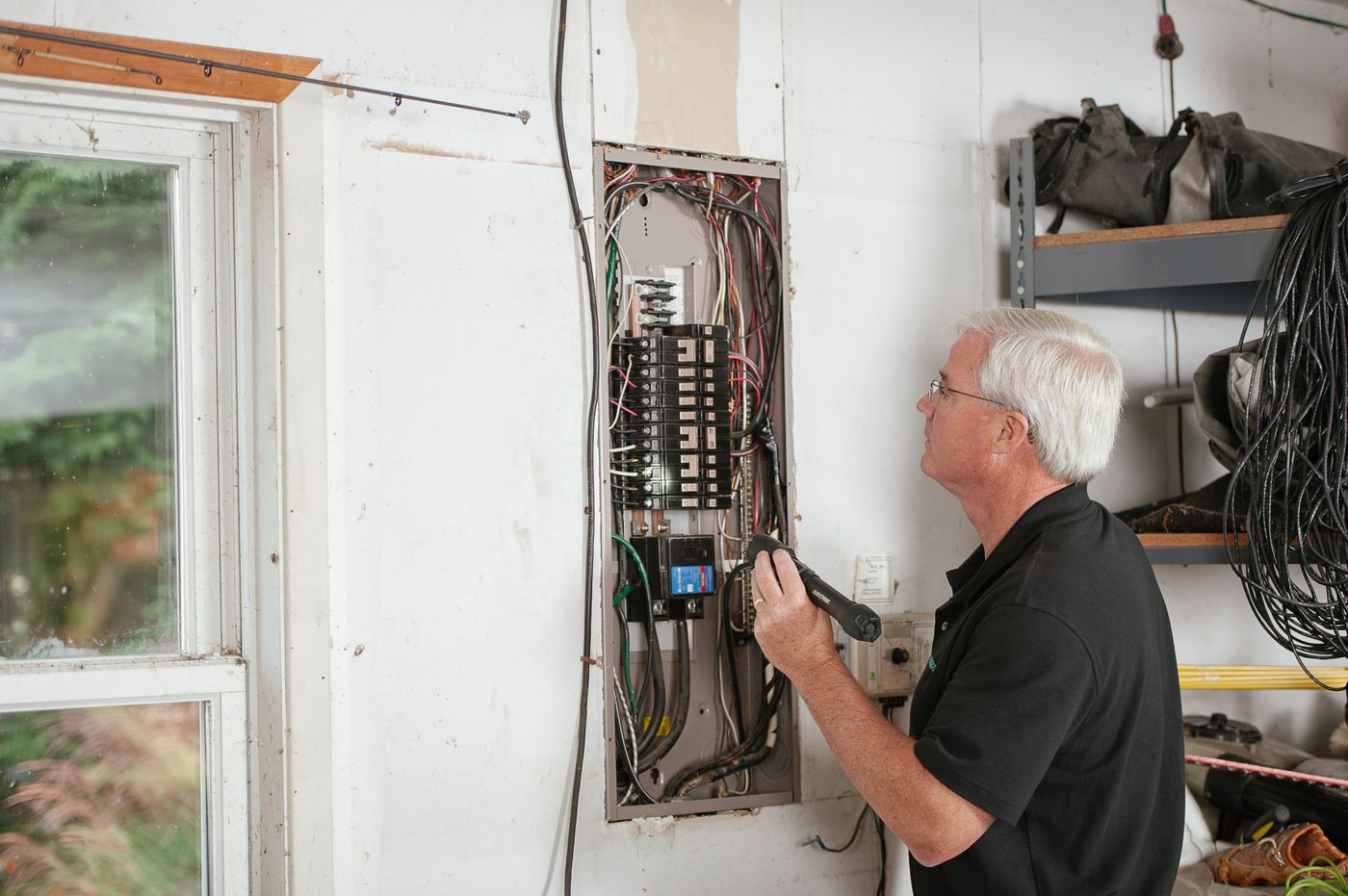 Electrician inspecting a residential fuse box — SEO results for electricians