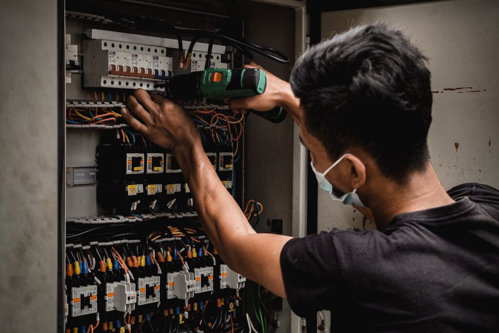 Electrician working inside a breaker panel, electrician SEO by Websza