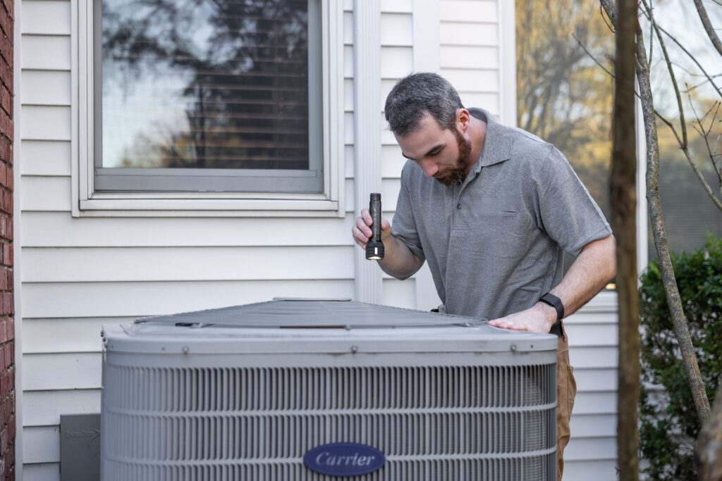 HVAC technician servicing an outdoor AC unit — local SEO for HVAC companies by Websza