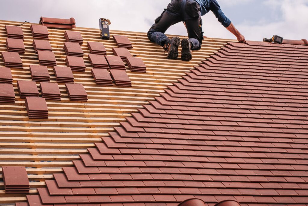 Roofer installing new tiles on a residential roof, roofing SEO by Websza