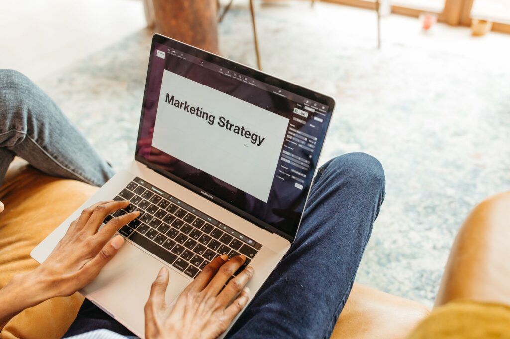 Hands on a laptop reviewing a content marketing strategy presentation to plan digital campaigns from start to finish