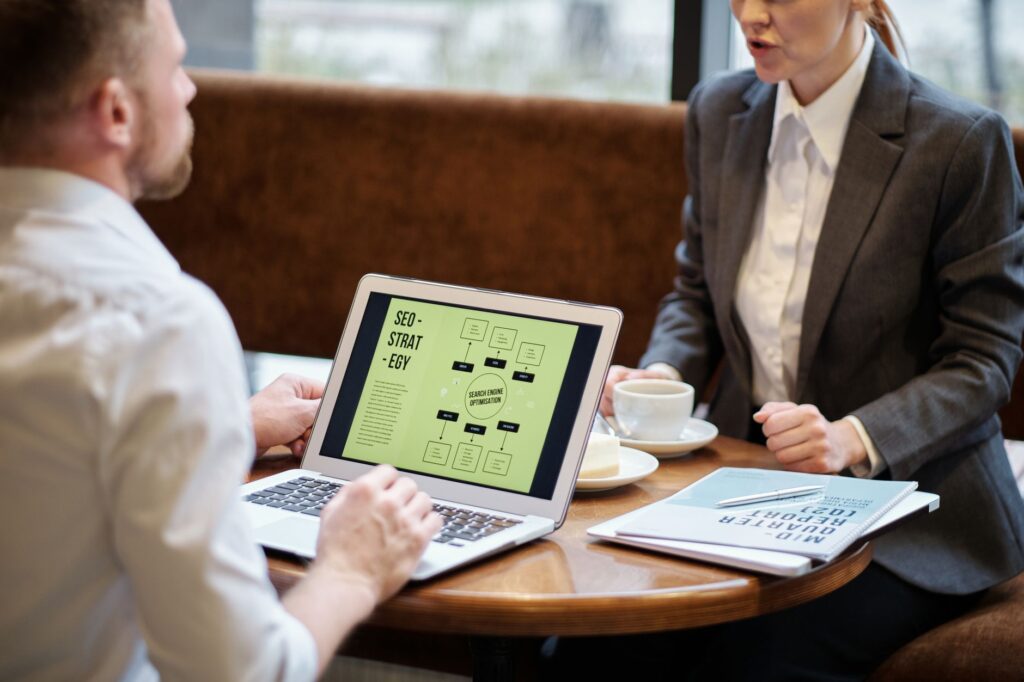 Man and woman discussing DIY versus professional SEO services strategy together at a cafe meeting