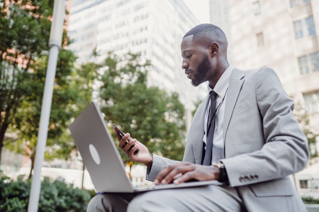 Contractor managing Google Local Services Ads on laptop and smartphone while working in a professional urban environment